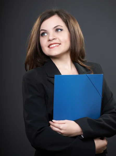 Happy young woman in a black jacket. Holds a blue folder and loo — Stock Photo, Image