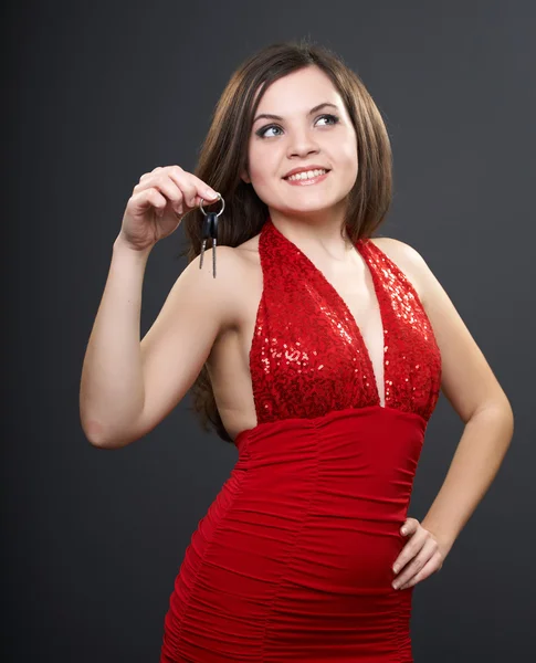 Kırmızı elbiseli çekici genç kadın. kadın anahtarları h içinde tutar. — Stok fotoğraf