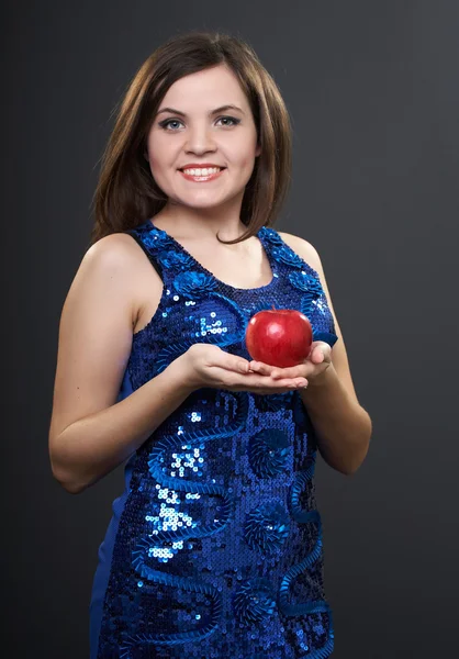 Attraktive junge Frau im blauen Kleid. Frau hält roten Apfel in der Hand. — Stockfoto