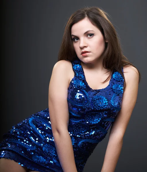 Attraktive junge Frau im blauen Kleid. Frau sitzt. — Stockfoto