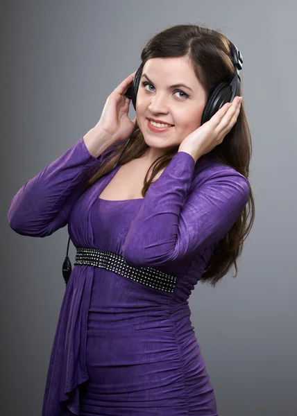 Jovem feliz com um vestido lilás. Mulher ouvindo música em — Fotografia de Stock