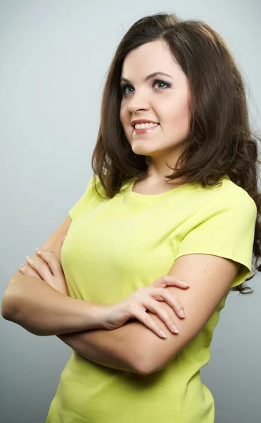 Gelukkig jonge vrouw in een gele shirt en spijkerbroek. staande wit — Stockfoto