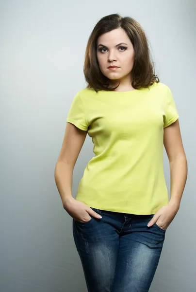 Jovem atraente em uma camisa amarela e jeans azuis . — Fotografia de Stock