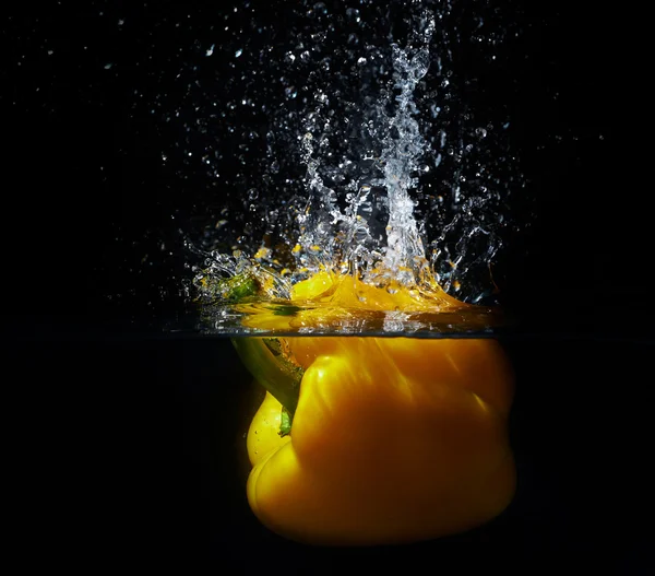 Frischer gelber Paprika fällt mit einem Spritzer wat ins Wasser — Stockfoto