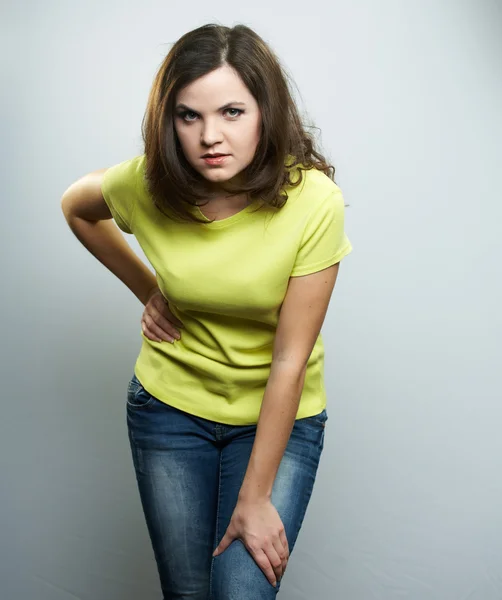 Aantrekkelijke jonge vrouw in een gele shirt en spijkerbroek. — Stockfoto