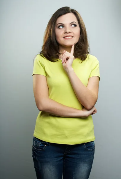 Gelukkig jonge vrouw in gele shirt en spijkerbroek. holding haar vinger — Stockfoto