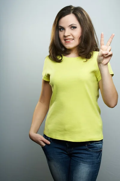 Happy young woman in a yellow shirt. Woman shows her left hand, — Stock Photo, Image