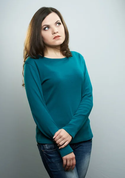 Attractive young woman in a blue shirt and jeans. Looks to the u — Stock Photo, Image