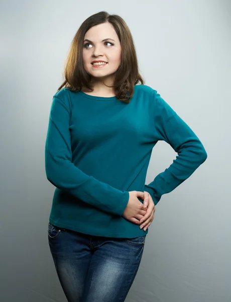 Attractive young woman in a blue shirt and jeans. Woman looks ri — Stock Photo, Image