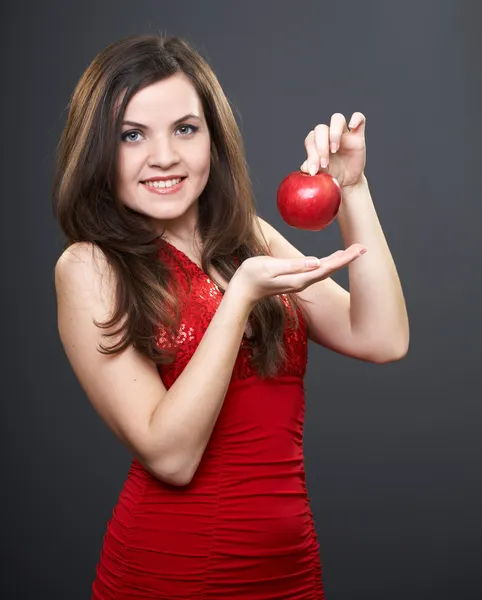 Joyeux jeune femme en robe rouge brillant. Femme tient une pomme rouge . — Photo