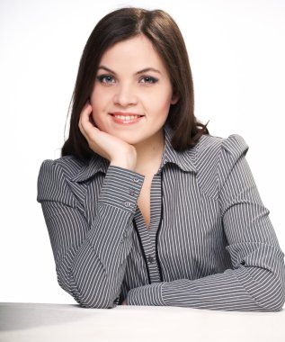 mutlu genç kadın masada oturan gri bir bluz.