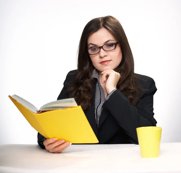 Attractive young woman in a black jacket and glasses sitting at — Stock Photo, Image