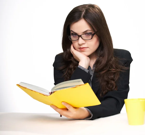 Atraktivní mladá žena v černé bundě a brýle sedí u — Stock fotografie