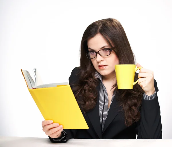 Attractive young woman in a black jacket and glasses sitting at — Stock Photo, Image