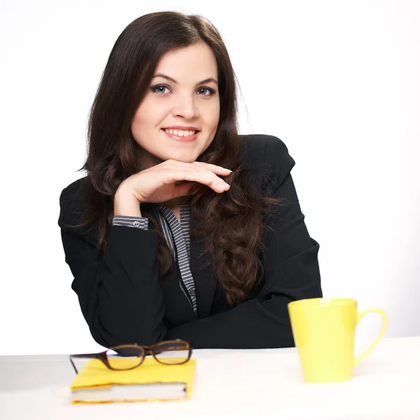 Jonge zakenvrouw in een zwarte jas aan de tafel. — Stockfoto