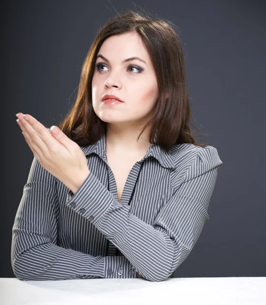 Attractive young woman in a gray blouse sitting at the table. Wo — Stock Photo, Image