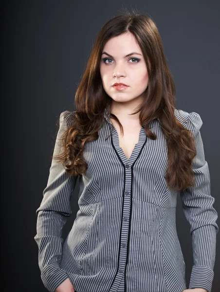 Una joven atractiva con una blusa gris. Mujer con larga oscuridad ha —  Fotos de Stock