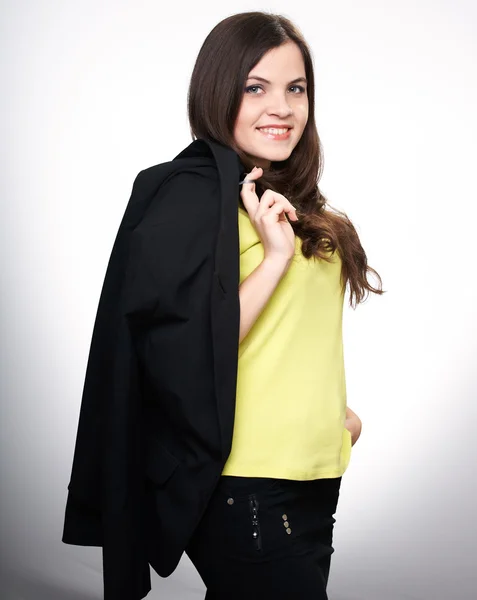Happy young woman in a yellow shirt. Woman holds a black jacket. — Stock Photo, Image