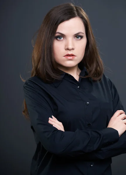 Attraktiv ung kvinna i en svart tröja med knäppta händer. — Stockfoto