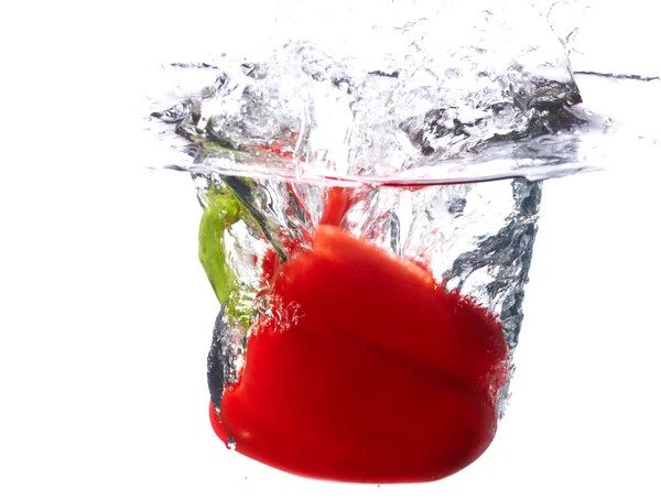Fresh red paprika falling into the water with a splash of water. — Stock Photo, Image