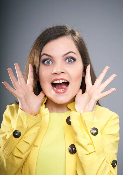 Mujer joven sorprendida con una chaqueta amarilla . —  Fotos de Stock