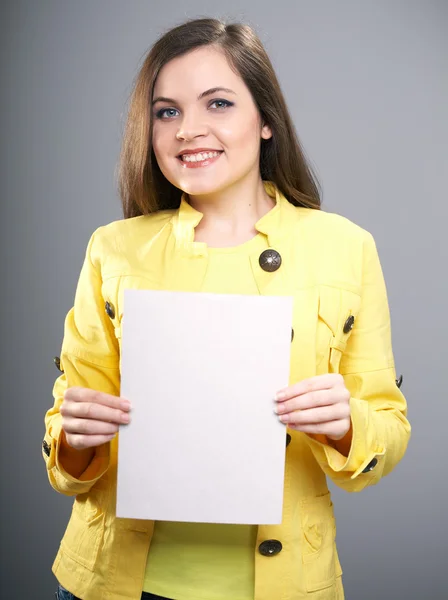 Ελκυστική νεαρή γυναίκα σε ένα κίτρινο σακάκι. γυναίκα κατέχει μια αφίσα. — Φωτογραφία Αρχείου