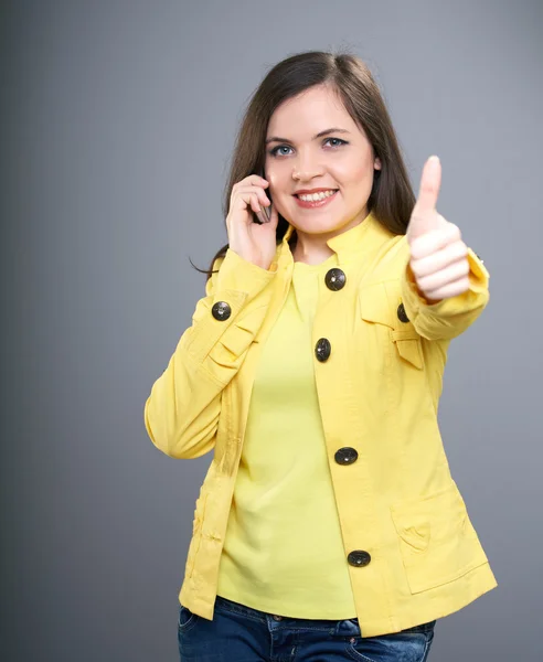 Mobil ph konuşurken sarı ceket çekici genç kadın — Stok fotoğraf