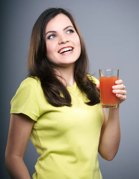 Giovane donna felice con una camicia gialla. Donna tiene un bicchiere di succo — Foto Stock