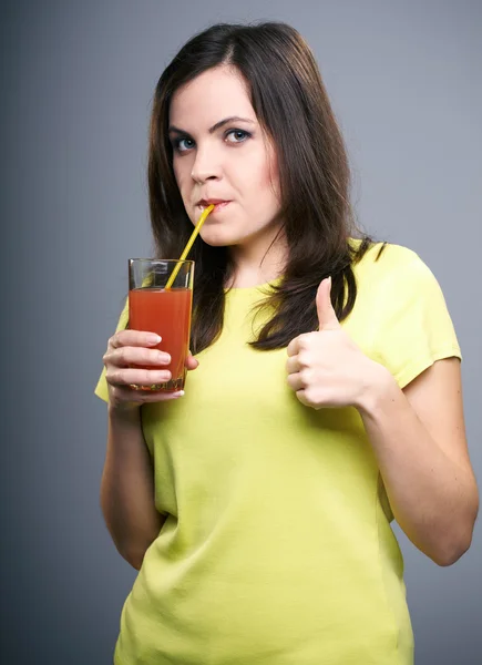 Una joven atractiva con una camisa amarilla. Mujer bebiendo jugo a — Foto de Stock