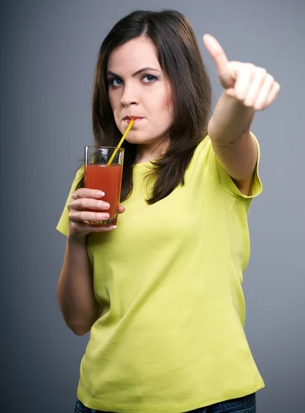 Una joven atractiva con una camisa amarilla. Mujer bebiendo jugo a — Foto de Stock