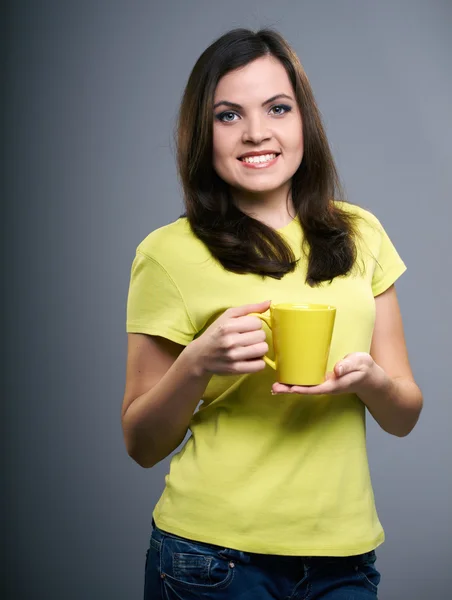Uma jovem atraente com uma camisa amarela. Mulher segura um c amarelo — Fotografia de Stock