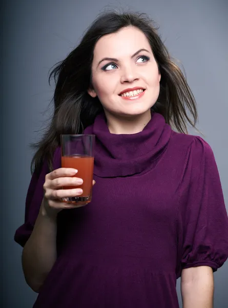 Giovane donna attraente in un vestito. Donna tiene un bicchiere di succo di frutta . — Foto Stock