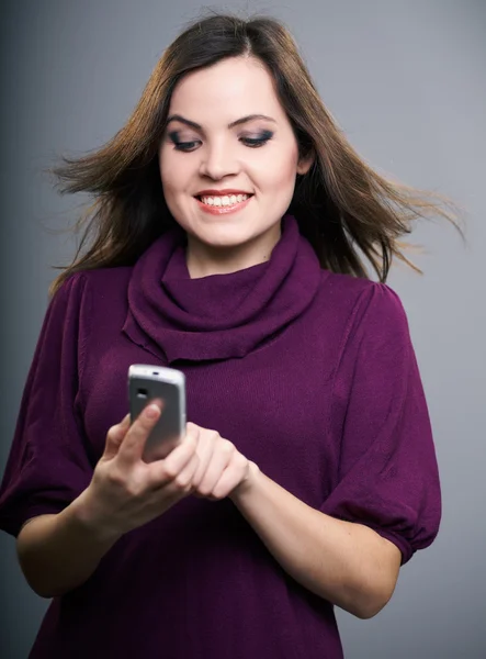 Attractive young woman in a dress. Woman holds a mobile phone an — Stock Photo, Image