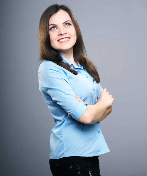 Aantrekkelijke jonge vrouw in een blauwe blouse. haar in beweging. op zoek — Stockfoto