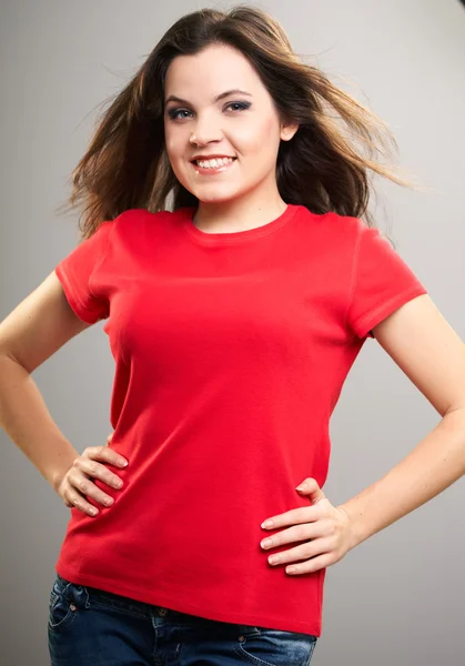 Vonzó fiatal nő, egy piros póló. mozgásban haját. — Stock Fotó