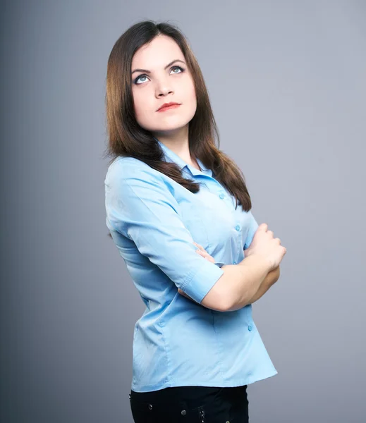 Attractive young woman in a blue blouse. Hair in motion. Looking — Stock Photo, Image