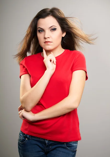 Uma jovem atraente com uma camisa vermelha. Mulher segura o dedo — Fotografia de Stock