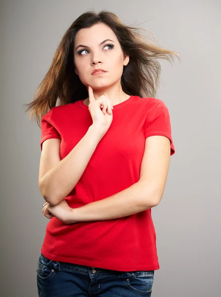 Una joven atractiva con una camisa roja. Mujer sostiene su dedo en —  Fotos de Stock