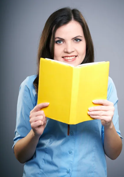 Aantrekkelijke jonge vrouw in een blauwe blouse. vrouw houdt een gele bo — Stockfoto