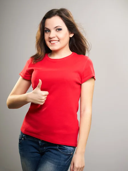 Una joven atractiva con una camisa roja. Mujer mostrando pulgares hacia arriba . —  Fotos de Stock