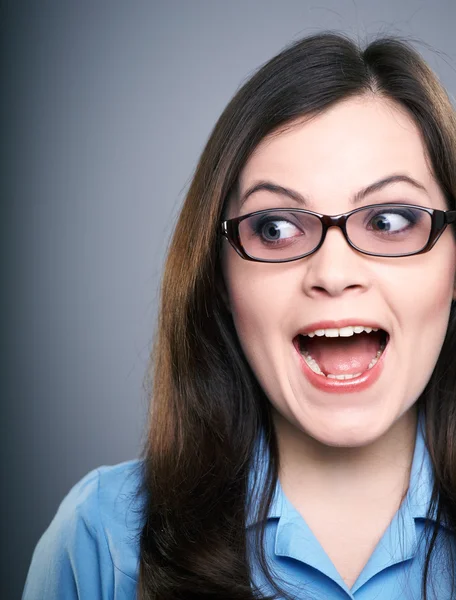 Surprised young woman in a blue blouse and glasses. Looking to t