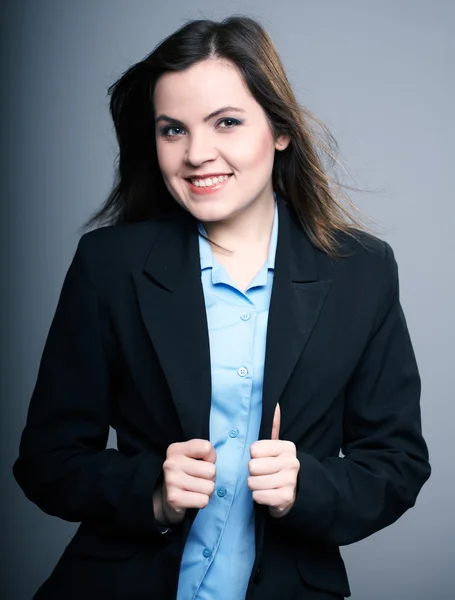 Attractive young woman in a black jacket. Hair in motion. — Stock Photo, Image