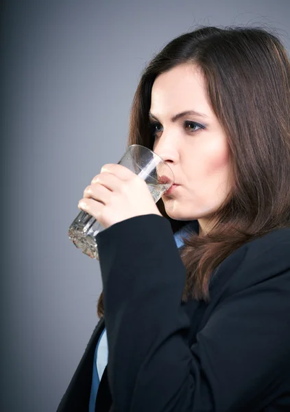 Attraktive junge Frau in schwarzer Jacke. Frau trinkt Mineralwasser — Stockfoto