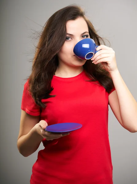 Attractive young woman in a red shirt. Woman drinking from a blu — Stock Photo, Image
