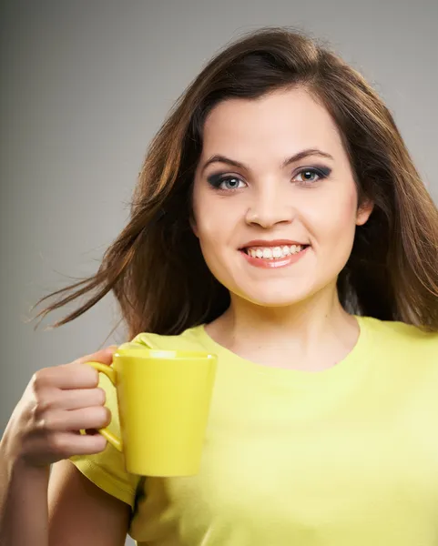 Attractive young woman in a yellow shirt. Woman holds a yellow c — Stock Photo, Image