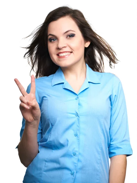 Viehättävä nuori nainen sinisessä paidassa. Nainen näyttää symbolin — kuvapankkivalokuva