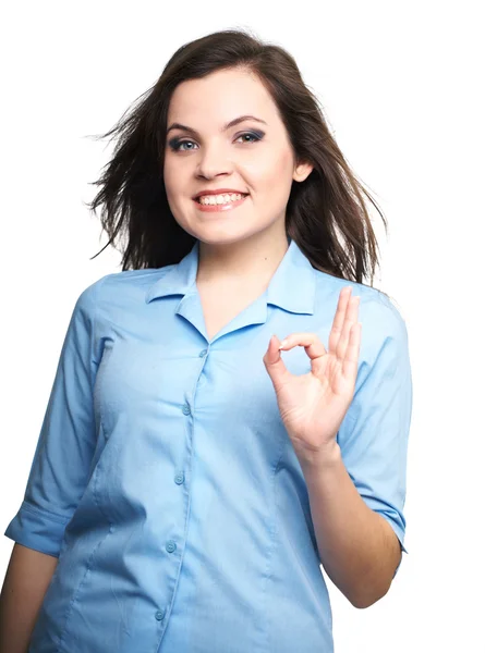 Attractive young woman in a blue shirt. Woman shows a sign okay. — Stock fotografie