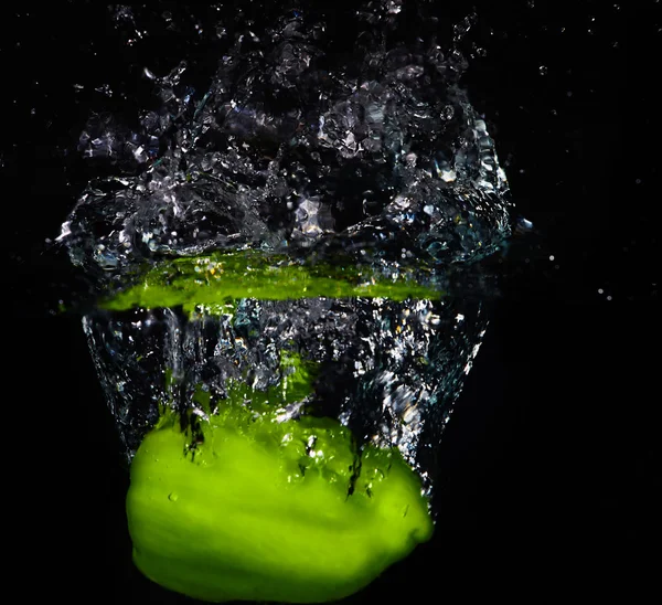 Fresh green paprika falling into the water with a splash of wate — Stock Photo, Image