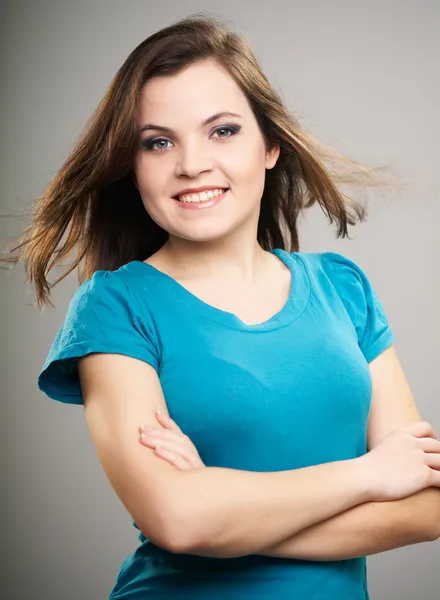 Una joven atractiva con una camisa azul. Mujer de pie con pliegue —  Fotos de Stock