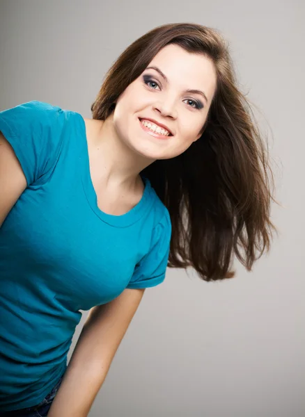 Aantrekkelijke jonge vrouw in een blauw shirt. haar in beweging. o — Stockfoto